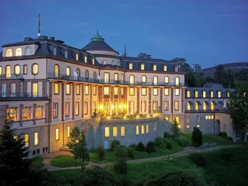 Schloss Bühlerhöhe in der Abenddämmerung mit beleuchteten Fenstern