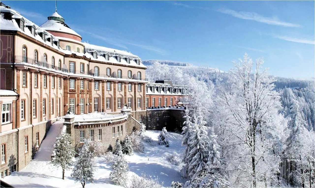 Schloss Bühlerhöhe im Winter, umgeben von verschneiten Tannen