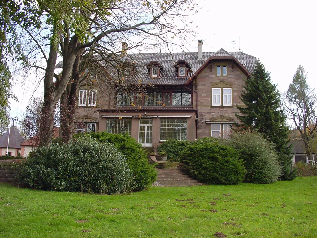 Jagdschloss aus Sandstein hinter alten Bäumen