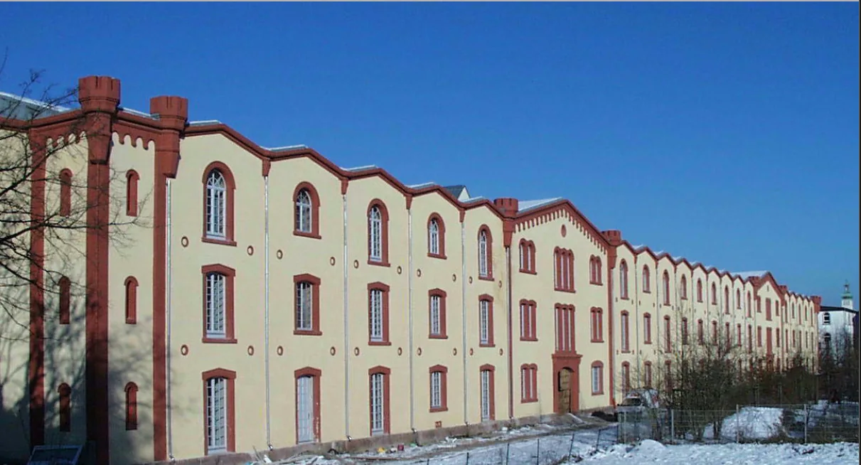 Langgestreckte historische Fassade des Körnermagazins mit roten Sandsteinlisenen