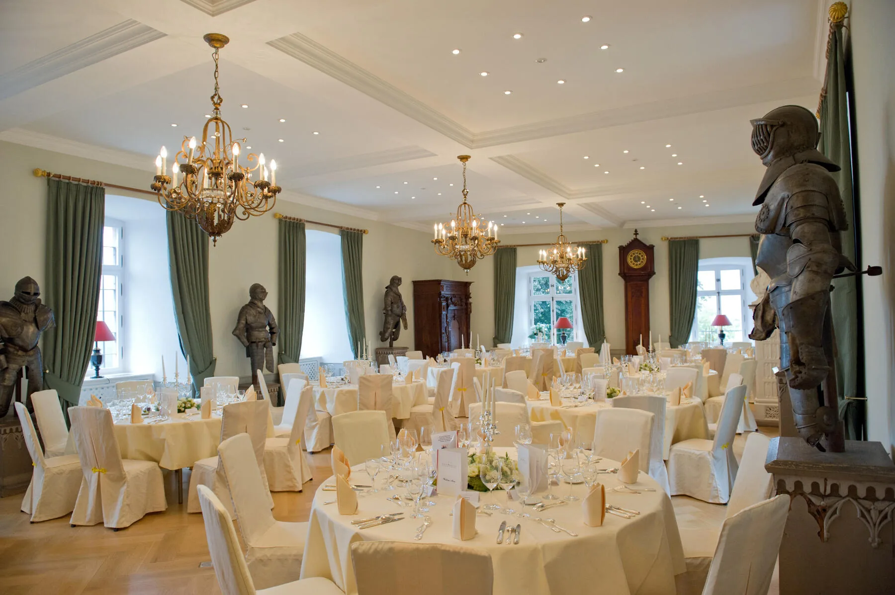 Festsaal mit Kronleuchtern, Kassettendecke und historischen Rüstungen